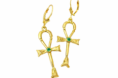 Gold ankh earrings with green gemstones on a white background