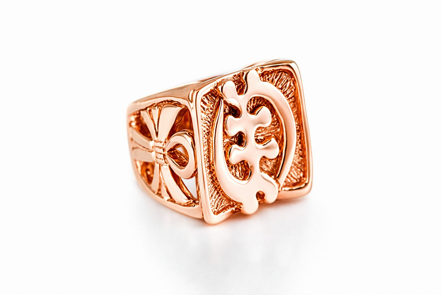 Rose gold gye nyame signet ring with intricate design on a white background