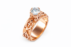 18k Rose gold Odo Nnyew Fie Kwan Adinkra ring with a diamond on a white background