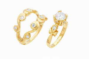 Gold ring set with diamond accents on a white background