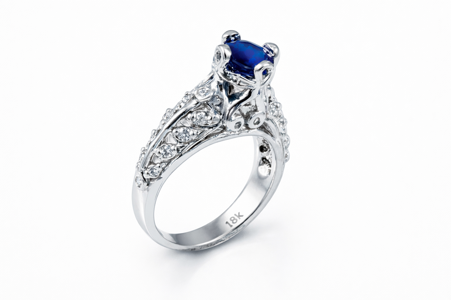 18k White Gold engagement ring with white diamonds and a Sapphire main stone. The main stone is held up with Ankh prongs