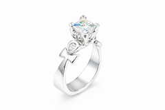 platinum three stone ring with a large diamond and smaller diamonds on a white background