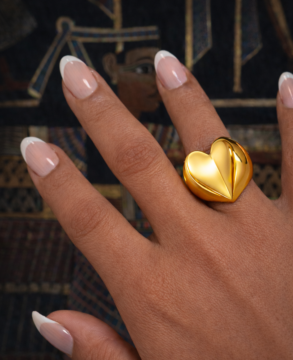 Chunky heart ring on a hand with a blurred background