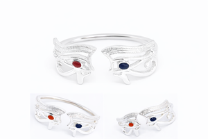 A silver bangle-style bracelet featuring a double eye design inspired by ancient Egyptian jewelry, with carnelian and lapis lazuli accents.