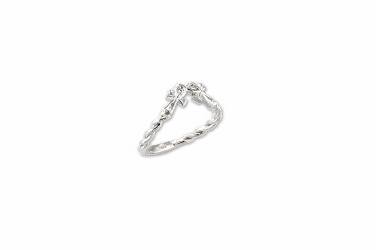 A double ankh ring mini with a looped band design, featuring two ankh symbols, set in a white gold band with small white diamonds.
