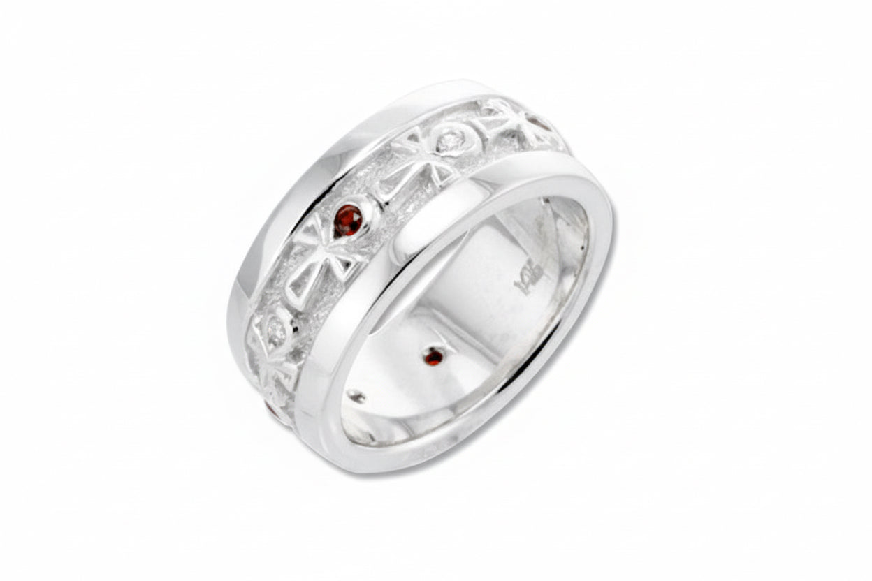 A wedding band ring with white gold borders, featuring alternating white diamonds and red garnets set within the bands.