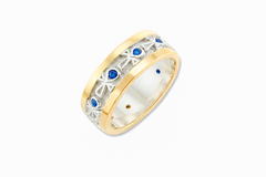 18k white and yellow gold ring with sapphires on a white background