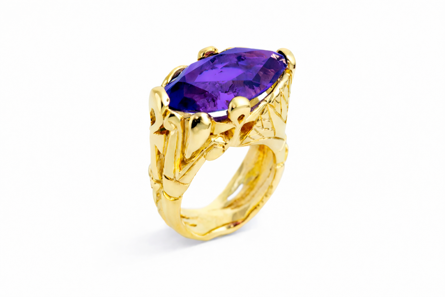 A gold cocktail ring featuring a main stone Amethyst, surrounded by four lotus flowers and two Ankhs intertwined, set in a textured gold band.