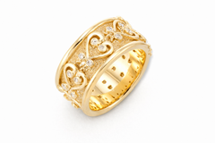 Gold ring with intricate Sankofa designs on a white background