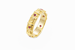 Gold thin ankh band with red gemstones on a white background