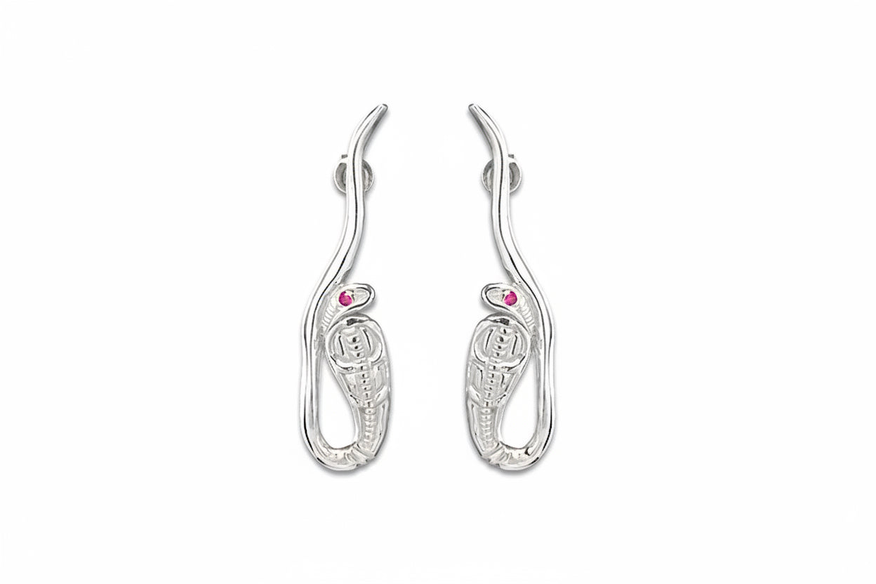 A pair of white gold cobra earrings with ruby eyes, featuring a textured surface and curved in shape.