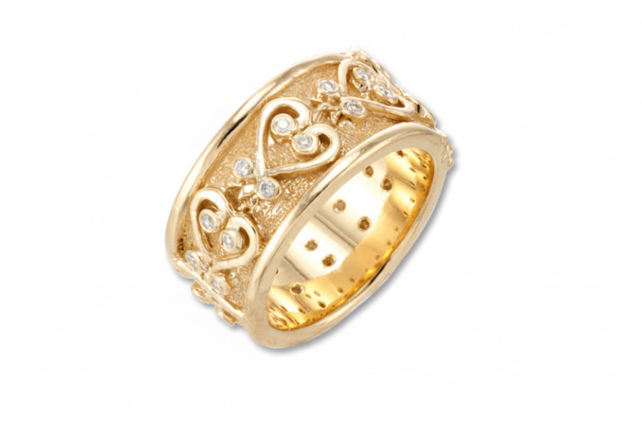An 18k yellow gold wedding band with Sankofa symbols carved out horizontally and a textured background, adorned with small diamonds.